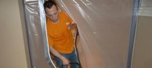 Water Damage Technician Using Air Mover Inside A Vapor Barrier